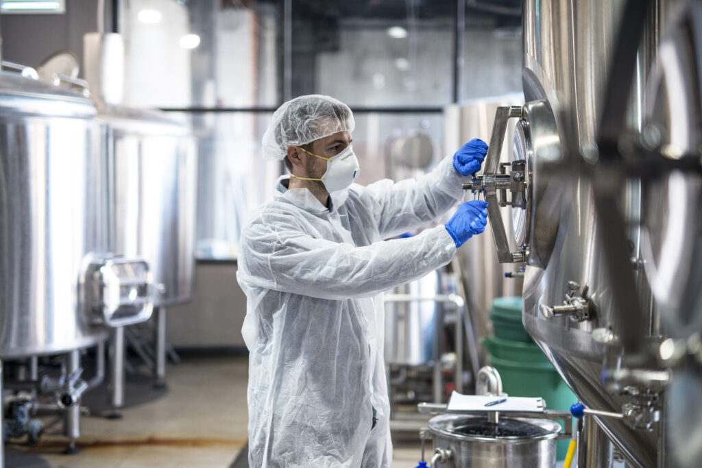 Technicien fermant une cuve industrielle en salle blanche
